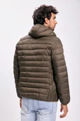 Campera capitoneada color verde con capucha y cierre frontal. Diseño acolchado y bolsillos laterales con cierre.