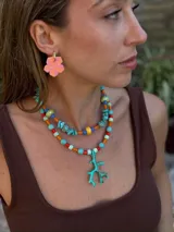 Collar corto con piedras turquesas irregulares, cuentas de cerámica amarillas y verdes, y cuentas plásticas naranjas y azules.