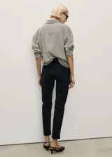 Pantalón de jean negro, tiro alto, corte mom fit, con cinco bolsillos y cierre de cremallera y botón.