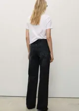 Pantalón de jean negro de corte wide leg, con tiro alto, cinco bolsillos, trabillas y bajo deshilachado.