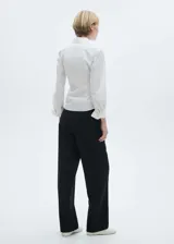 Pantalón de vestir negro de corte recto, con tiro medio, pinzas delanteras, bolsillos laterales y traseros de ribete.