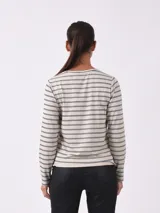 Remera de manga larga color azul oscuro con estampado de pequeñas hojas o puntos en blanco/gris claro. Presenta detalles de botones dorados en el escote del hombro.