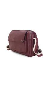 Bandolera bordeaux de cuero sintético con apertura central con cierre metálico. Tiene un bolsillo principal con cierre y un bolsillo frontal con tapa y broches magnéticos. Incluye bolsillos internos y posterior, y correa de galón combinada larga y regulable.
