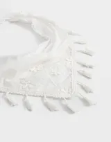Vincha tipo bandana de tela blanca con bordado de flores y terminaciones con borlas. Se ata con lazos.