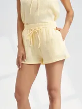 Short de tela color amarillo pastel con cintura elastizada y lazo de ajuste.