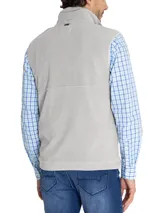 Chaleco polar gris sin mangas, confeccionado en micropolar de poliéster reciclado, con cierre frontal y tres bolsillos con cierre en color azul.