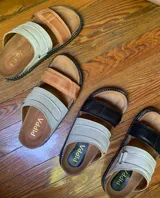 Sandalias bajas de cuero color tostado y beige, con doble tira ancha y plantilla de cuero.