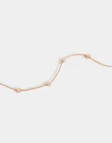 Collar corto dorado oro rosa con cadena fina y dijes de corazones pequeños distribuidos a lo largo de la cadena.