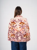 Chaqueta color crema con bordados florales en tonos tierra, rojizos y morados.
