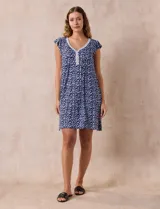 Camisón corto negro con estampado de lunares blancos, escote en V con puntilla blanca y botones.