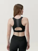 Top deportivo negro de alta sujeción, con tejido Shapplex_B y diseño con estampado reflectante en la espalda.