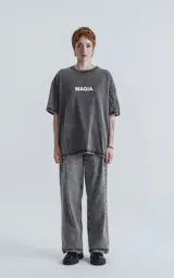 Remera manga corta gris con efecto nevado, cuello redondo y calce oversize. Estampa frontal con la palabra 'MAGIA' en color gris claro.