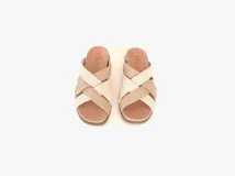 Sandalias bajas de cuero color beige con tiras cruzadas en cuero color blanco.