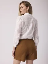 Short verde de lino sastrero con pinzas delanteras y bolsillos laterales.