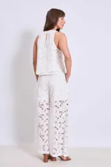 Pantalón palazzo blanco de broderie con cintura alta y pierna ancha.