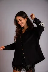 Camisa celeste de corte clásico, con botones frontales y bordados florales en las mangas.
