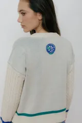 Buzo azul marino tejido en jacquard con diseño de frutas y verduras. Tiene mangas tejidas en ochos, bordado en la espalda y puños con agujerito para el dedo.