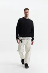 Buzo tejido de punto negro, de corte oversize, con cuello redondo y puños.