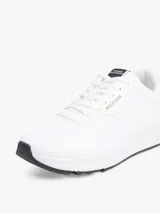 Zapatillas deportivas Tommy Hilfiger de corte bajo, color blanco, confeccionadas en tejido de punto de poliéster, con forro de poliéster, plantilla extraíble de poliuretano y suela de EVA. Presentan logo Hilfiger en relieve en el lateral y cinta distintiva en la entresuela.
