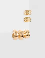 Set de aros que incluye tres argollas y dos earcuffs estilo chunky de metal dorado.