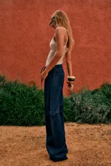 Pantalón denim fino color marrón, de corte amplio y tiro alto, con elástico en la parte trasera de la cintura y lazo ajustable.