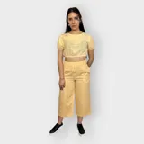 Pantalón color amarillo, de corte amplio y cintura elástica, con largo hasta los tobillos.