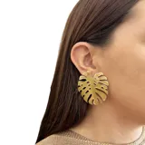 Aros colgantes con forma de hoja de monstera, hechos en metal con esmalte color mostaza.