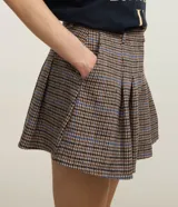 Short pollera con estampa de cuadros, cintura con trabillas, cierre por vista oculta y bajo plisado.