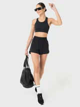 Top deportivo negro con espalda de diseño único y almohadillas removibles.