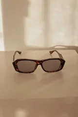 Lentes de sol con marco geométrico color carey y lentes grises con protección UV400.