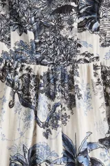 Vestido midi con breteles finos, escote cuadrado y espalda fruncida. Presenta un estampado de tigres, elefantes y vegetación en tonos azules sobre fondo blanco.