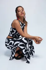 Vestido largo con estampado abstracto en blanco y negro, corte semi halter, aberturas laterales en la cintura y tajos laterales en la falda.