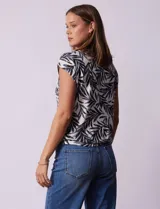 Blusa de modal con estampado de hojas en tonos azulados, escote en V con botones y ruedo anudado.