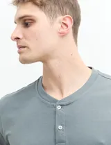 Remera manga corta con cuello redondo y tapeta con dos botones.