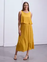 Vestido largo color mostaza, sin mangas, con escote redondo y detalle de crochet en los hombros.