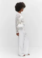 Pantalón de jean blanco de corte ancho, tiro alto y cintura elastizada con volados.