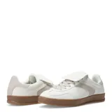 Zapatillas deportivas acordonadas color beige con suela marrón.
