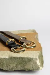 Cinturón marrón con hebilla dorada.