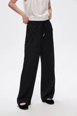 Pantalón negro de rayon, corte amplio, tiro alto y bolsillos laterales.