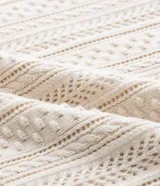 Musculosa de algodón color crema con cuello redondo y textura calada tipo ganchillo en franjas verticales.