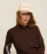 Gorra de sarga color beige con visera marrón, bordado frontal con la inscripción "California West Coast" y ajuste trasero.