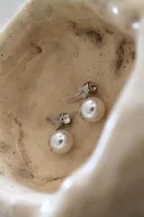 Aro con diseño de perla y detalle brillante en la parte superior.
