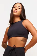 Top deportivo negro con cuello halter y espalda descubierta. Confeccionado en poliamida y elastano con protección UV50+.