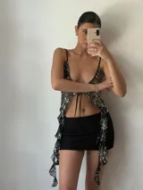 Top de fiesta negro con lentejuelas plateadas, escote en V y tirantes finos.