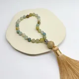 Japa Mala elaborado con 27 cuentas de piedra amazonita de 8 mm de diámetro, cuenta guru de Buda de metal y borla de hilo color crema.