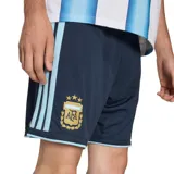 Short de fútbol Adidas de la selección Argentina, modelo 26, color azul marino con detalles celestes. Presenta el escudo de la AFA bordado en la pierna izquierda y las tres tiras características de Adidas en los laterales.
