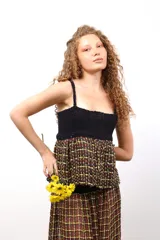 Top con parte superior de crochet negro y parte inferior de tejido plano de telar con diseño a cuadros en tonos amarillo, rojo y negro.