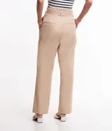 Pantalón pantacourt color beige, confeccionado en tricolina. Presenta cintura clochard con trabillas, pliegues delanteros y bolsillos laterales. Incluye cinturón con hebilla rectangular con estampado carey.
