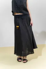 Falda larga de lino color negro, de silueta amplia y pretina elastizada.