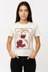 Remera de manga corta color crudo con estampado de flores abstractas en tonos borgoña y beige dentro de un marco rectangular marrón.